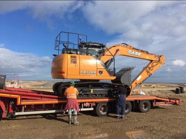 A CASE tracked excavator being delivered to site on a low-loader